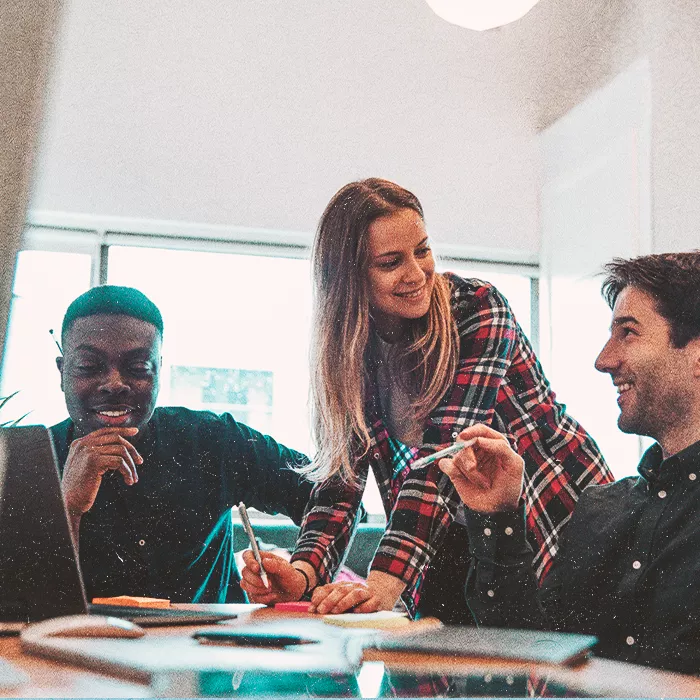 Three colleagues working together by a desk