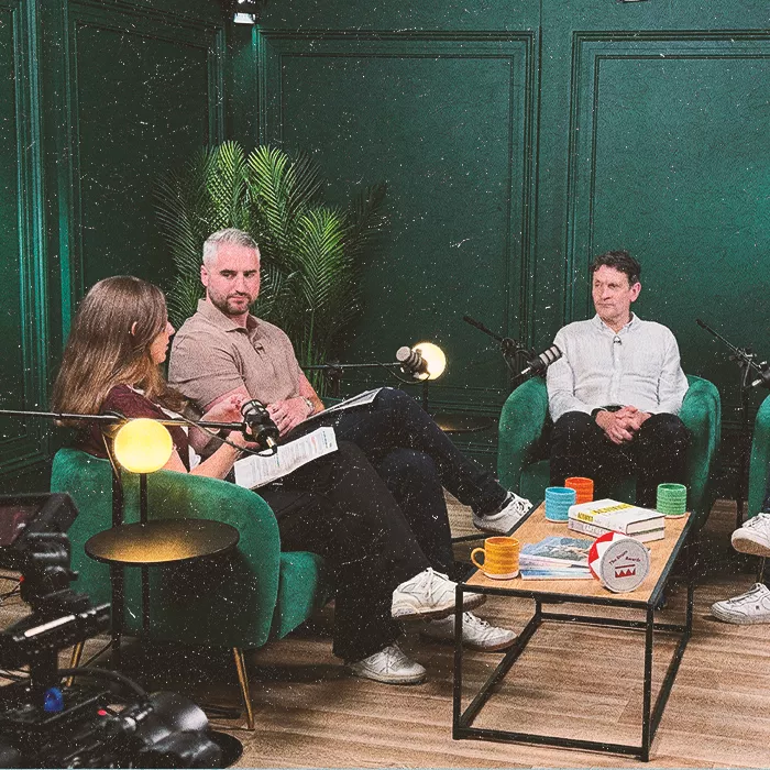 Three people sitting down recording podcast