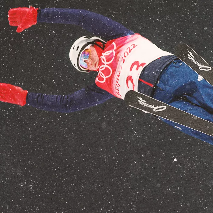 Ski jumper mid-jump photographed from below