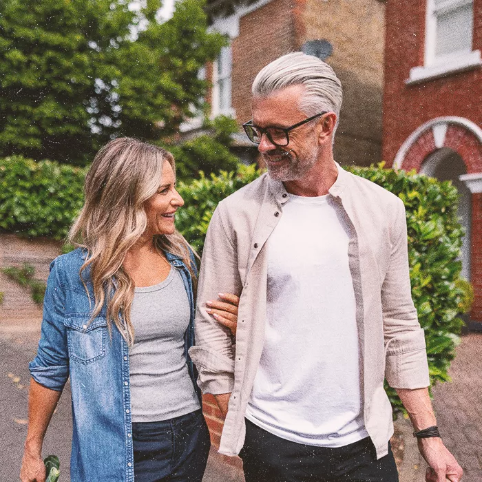 Couple walking together outside smiling towards each other
