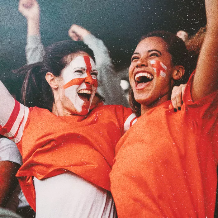 Two people with painted English flags on their cheeks cheering