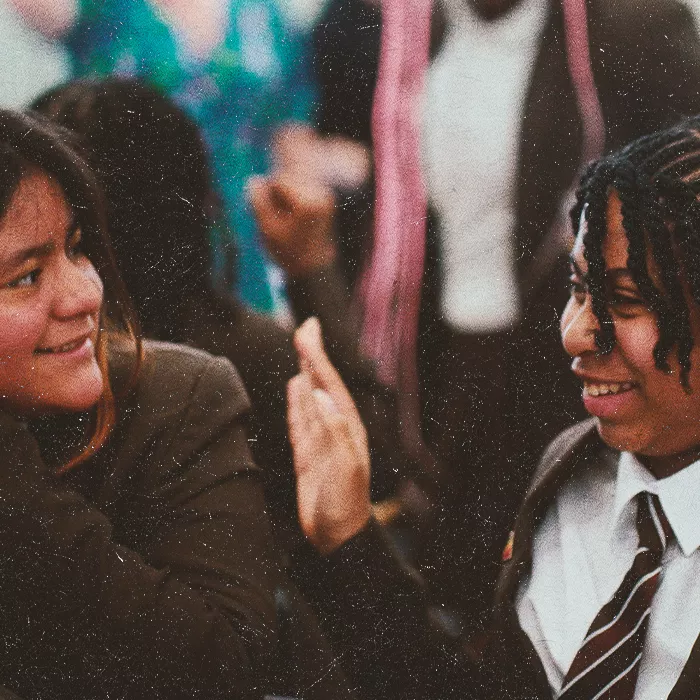 Two students smiling towards eachother
