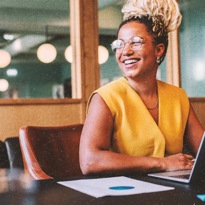 Woman sitting at a desk looking to the left and smiling