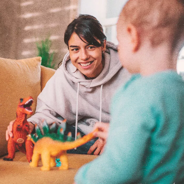 Woman playing with toys smiling at a child