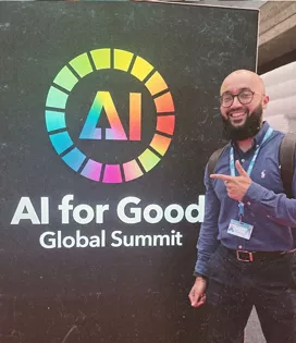 Man smiling and pointing at poster saying AI for Good