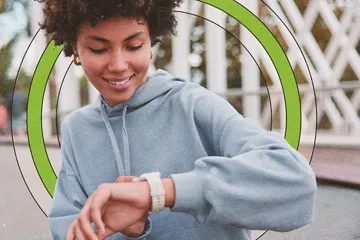 Smiling woman looking at her smart watch