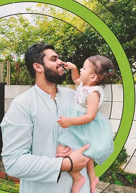 Smiling man holding small child