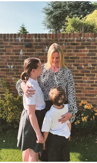 Smiling woman hugging two children