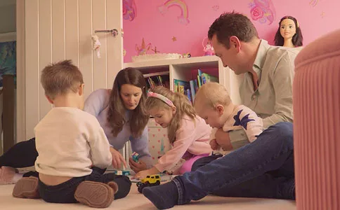 Family with small children playing together in a room
