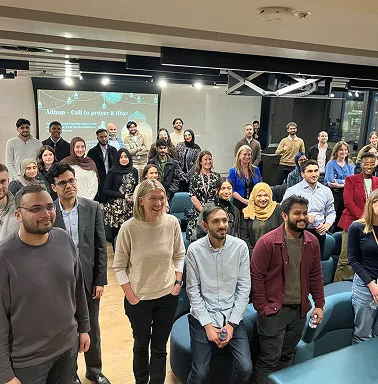 Colleagues standing together in a room celebrating
