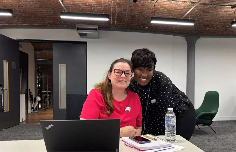 Two women working together smiling towards the camera
