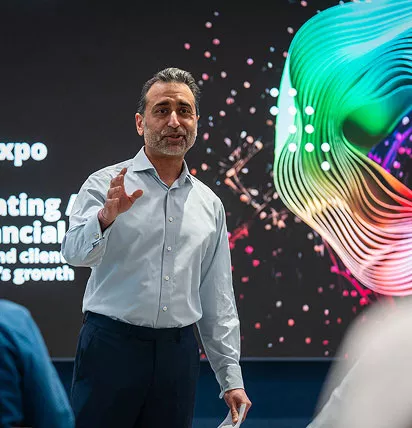 Man standing facing the audience holding a presentation