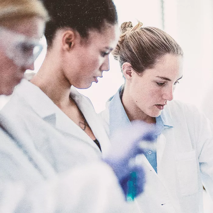 Three people in lab coats working