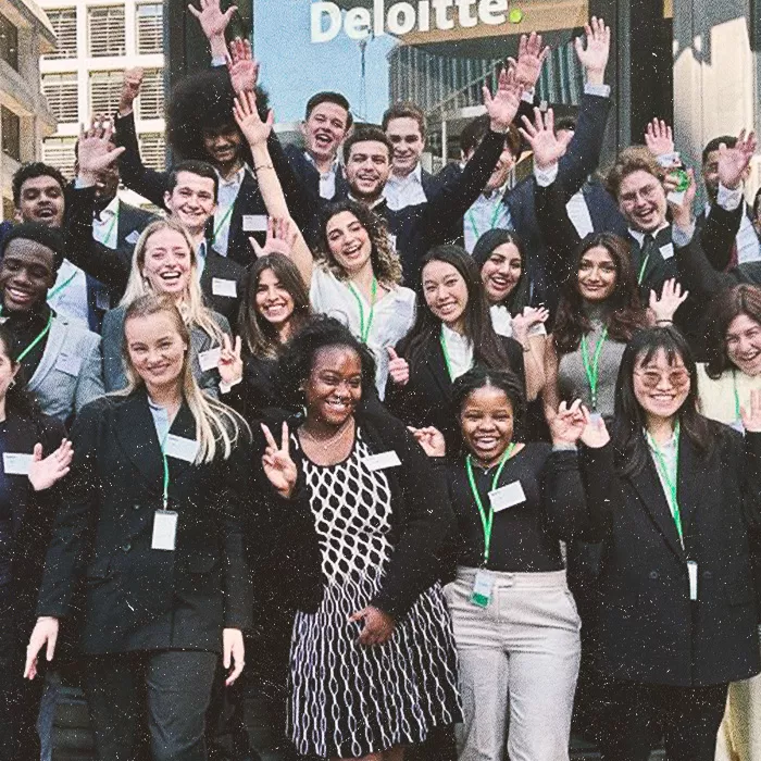 Group of happy people standing outside Deloitte building