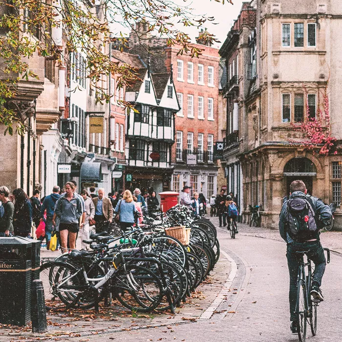 Man biking on city street with bi-cycles parked in row along the street