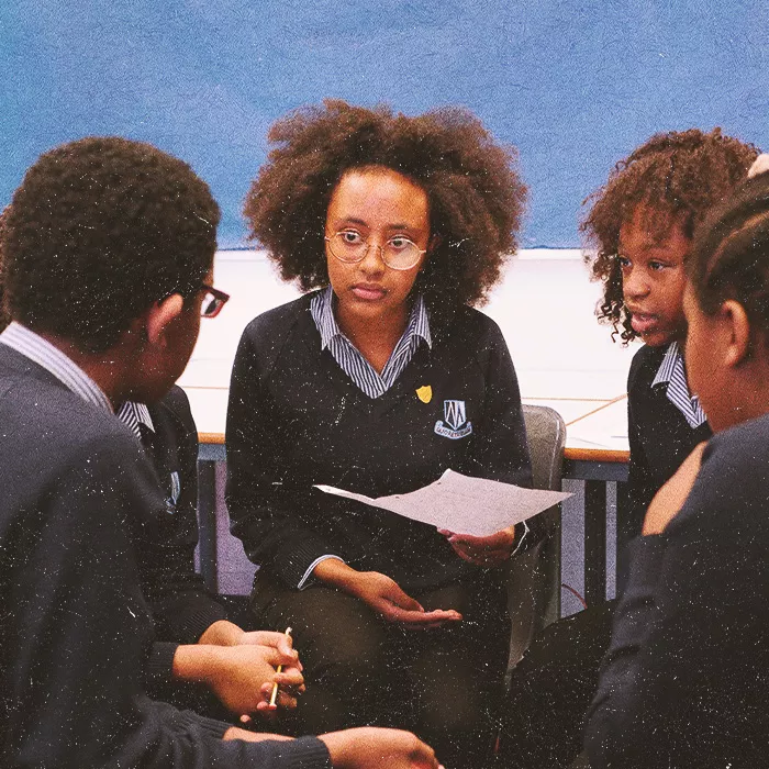 Five students sitting in a circle talking