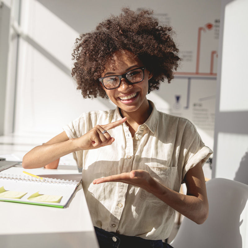 A person in an office communicating with sign language.