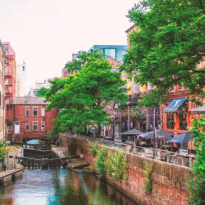 City canal with outdoor seating on street next to it