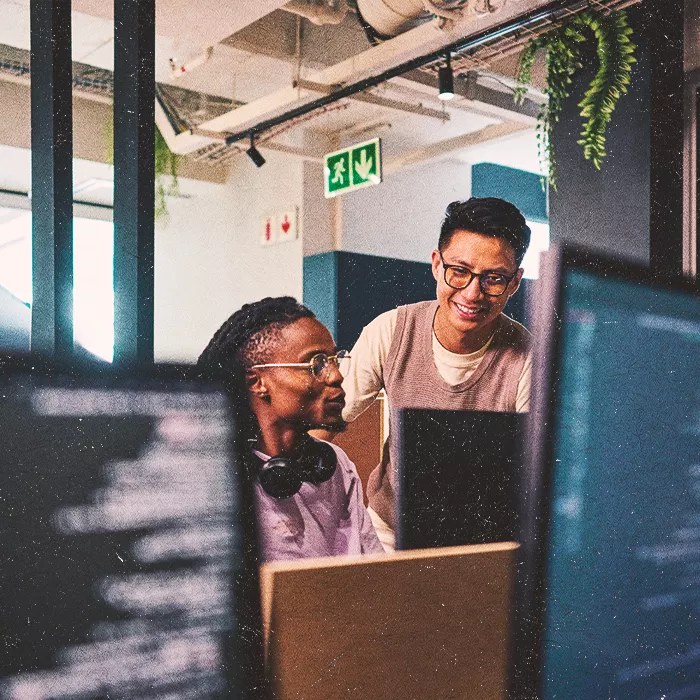 Two men working together at a computer screen