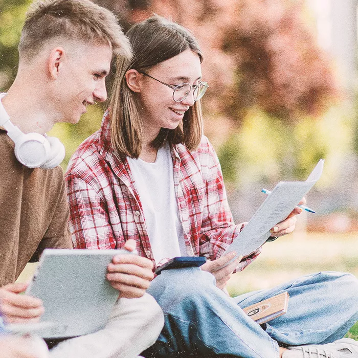 Two young people sitting outside studying together